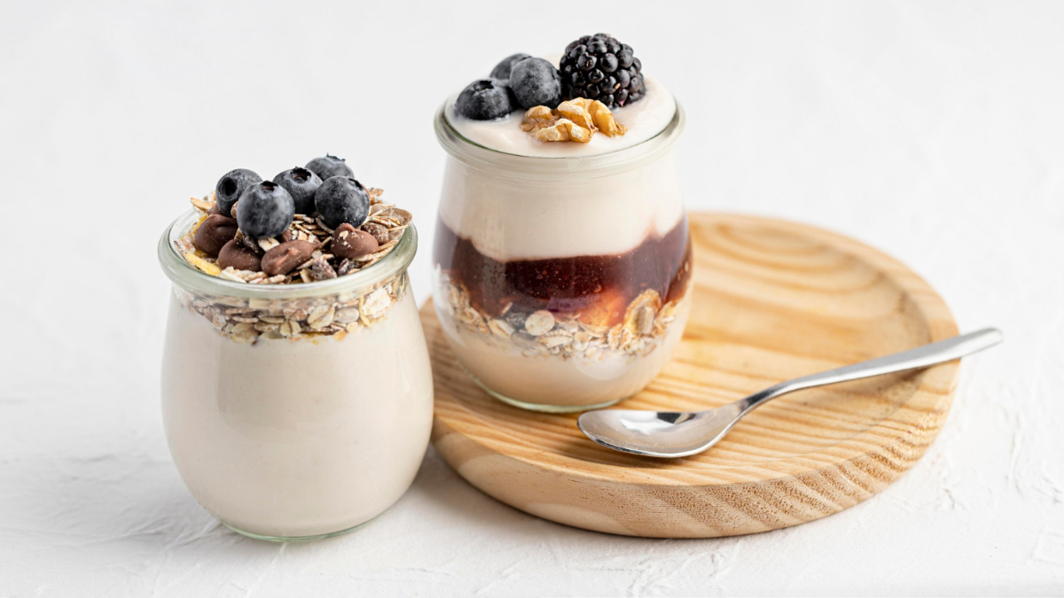 Dos yogures con avena, frutas del bosque, sirope y otras semillas.