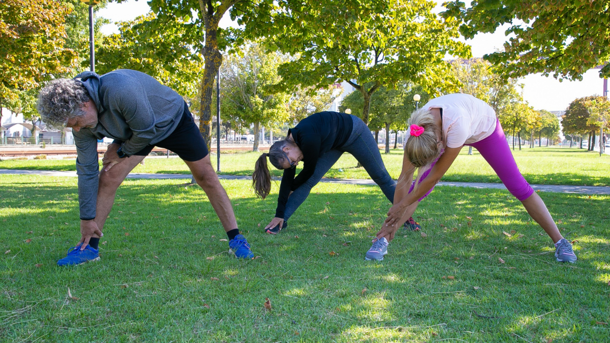 Un grupo de personas adultas realizan deporte al aire libre