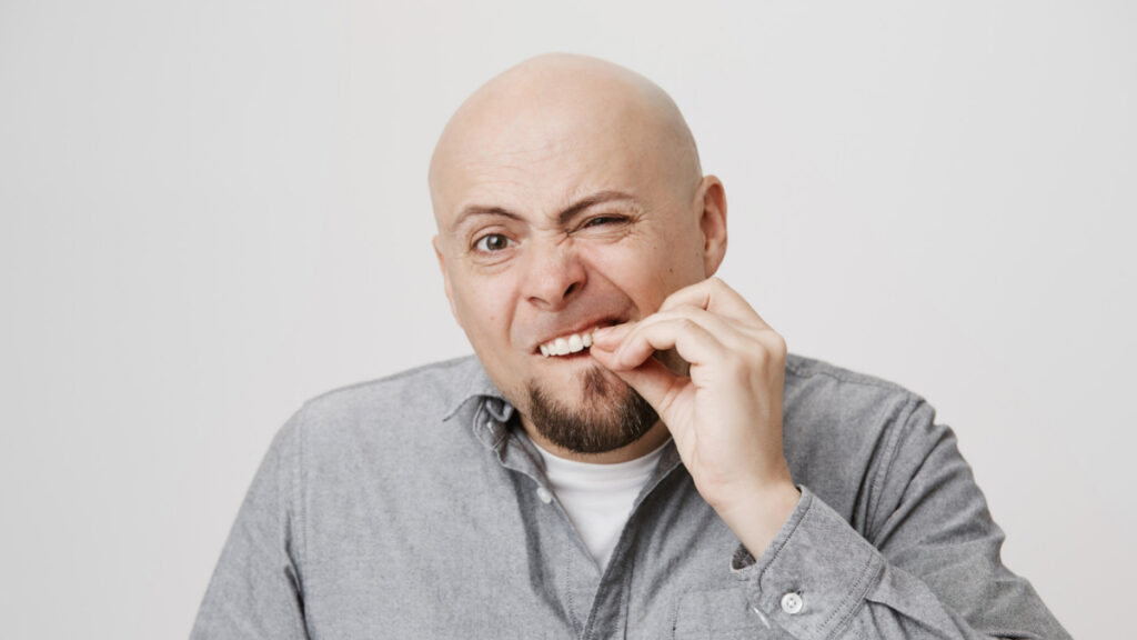 Un hombre de mediana edad se toca los dientes