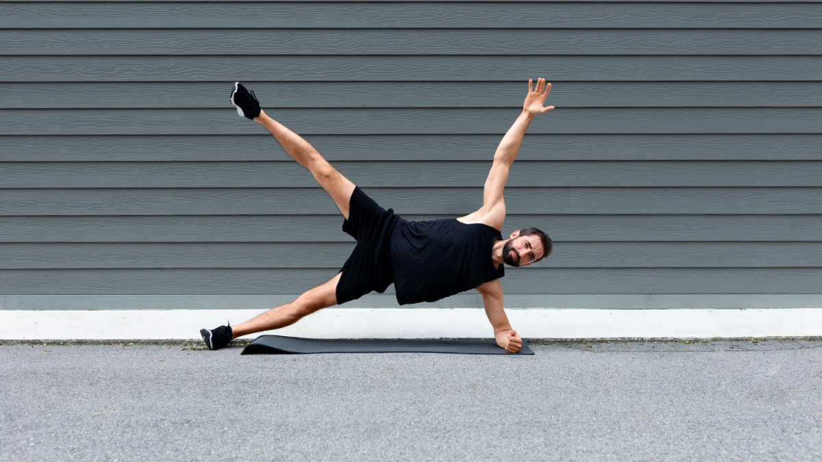 Un hombre realiza una plancha lateral en una esterilla.