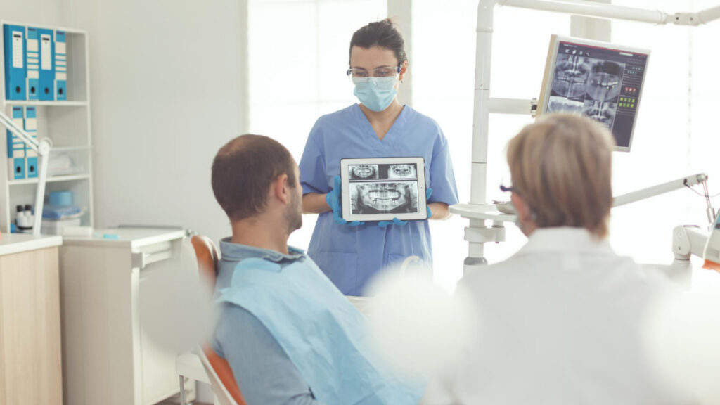 Un hombre ve una radiografía de su boca en una clínica odontológica.