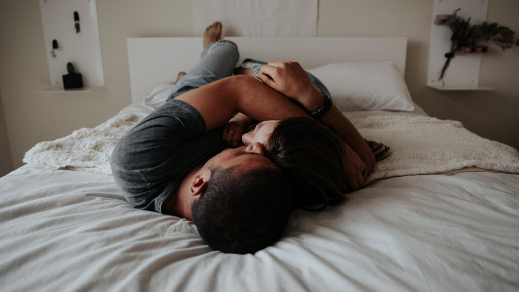 Un hombre y una mujer se abrazan en la cama
