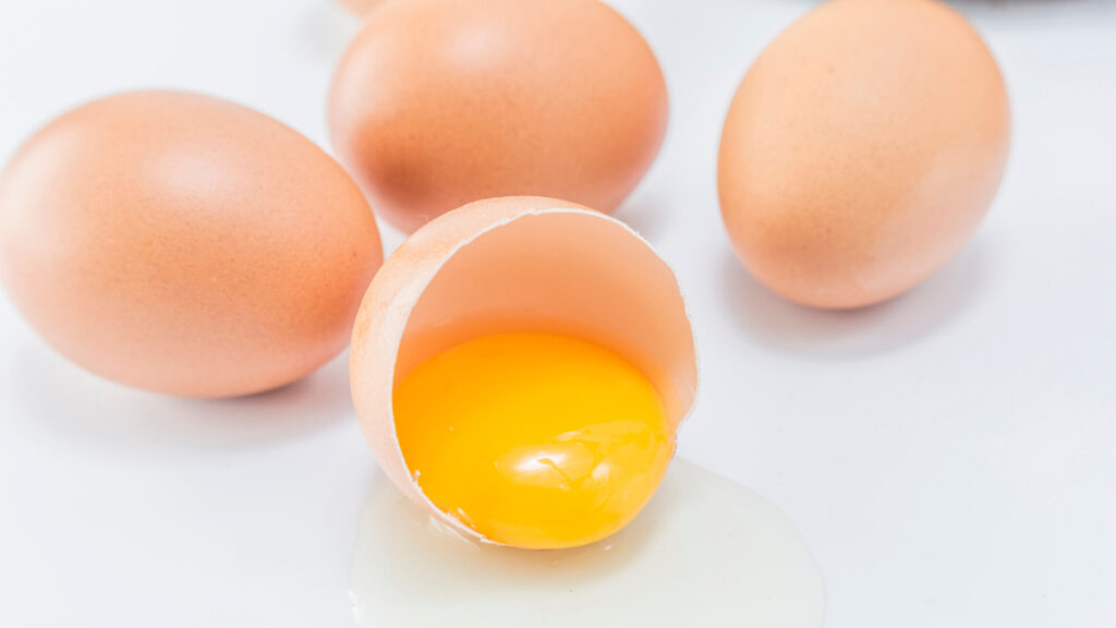Una yema de huevo, fuente de vitamina D, fuera de su cáscara.