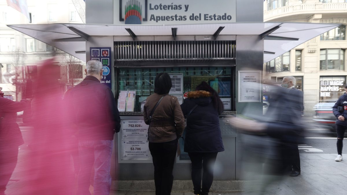 Personas comprando décimos de lotería.