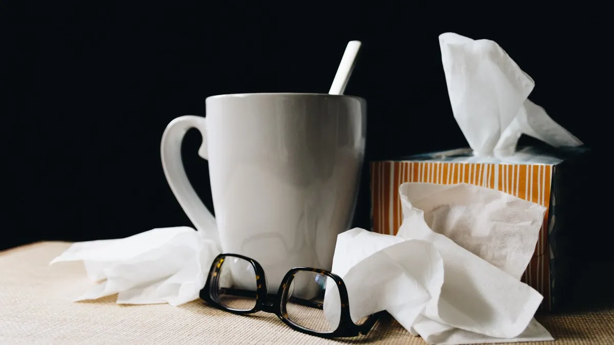 Una taza, unas gafas y un paquete de pañuelos 