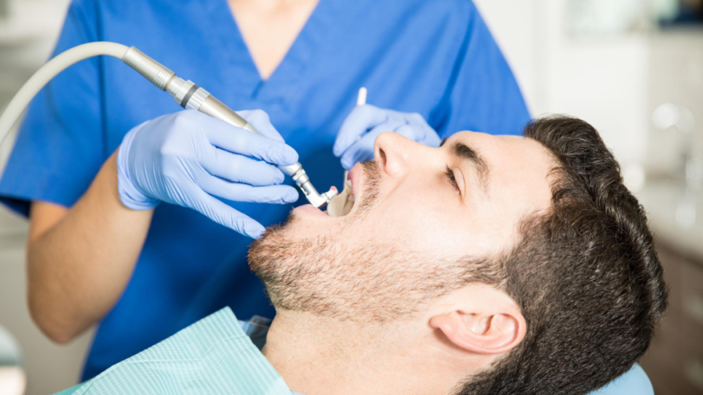 Un hombre recibe un tratamiento de salud dental en una clínica odontológica