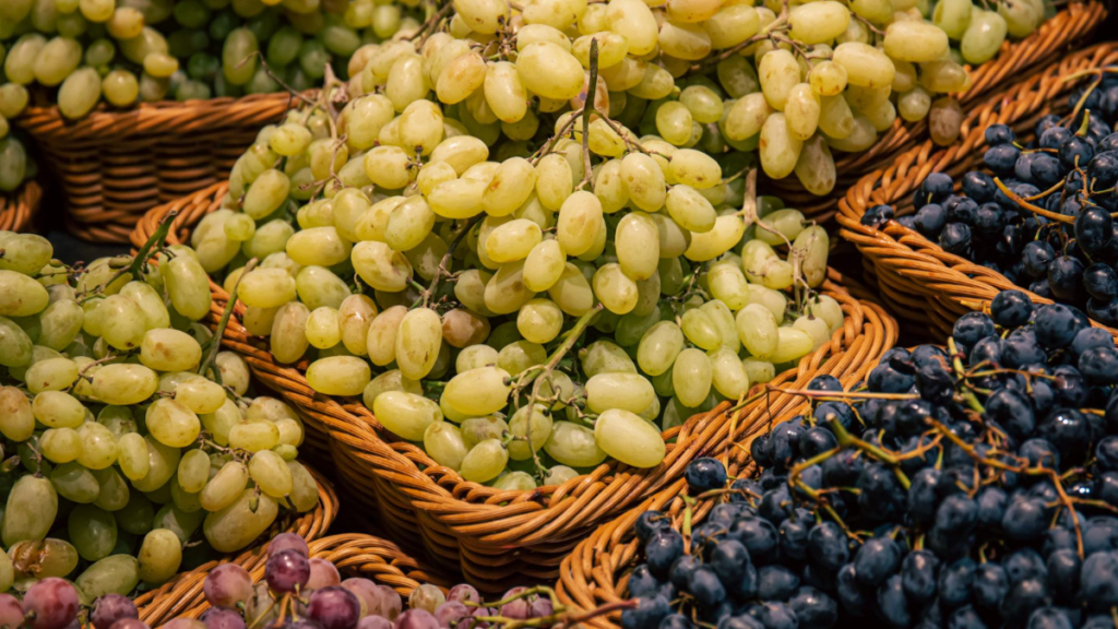 Varias cestas con uvas blancas y rojas