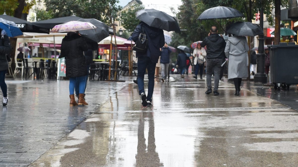 Personas caminando por la calle con paraguas