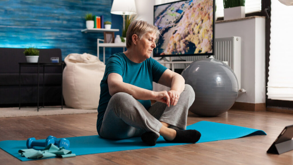 Una mujer hace una pausa durante el ejercicio físico en casa