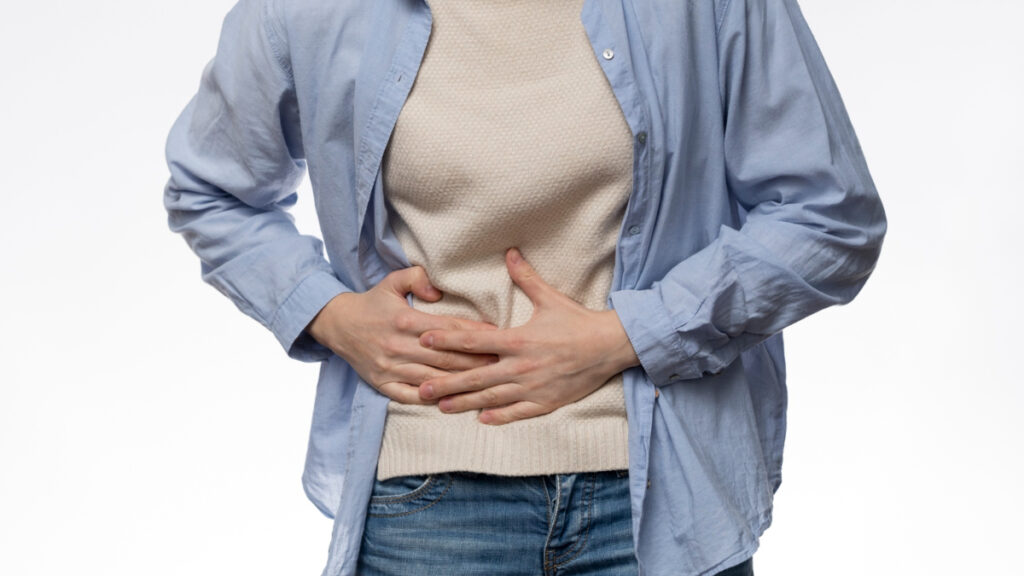 Un paciente con reflujo gastroesofágico se toca el abdomen
