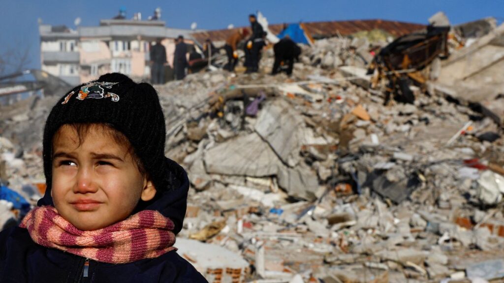 Una niña frente a los escombros de un edificio caído por el terremoto de Turquía. Foto: Reuters.