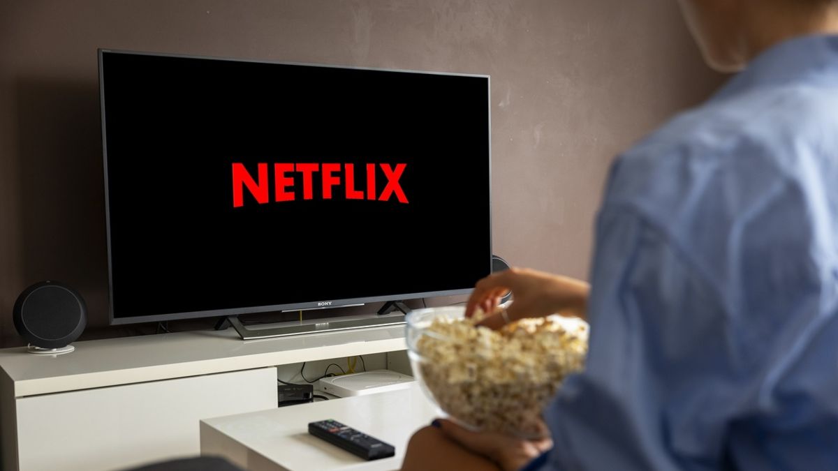 Un apersona viendo Netflix con palomitas. 