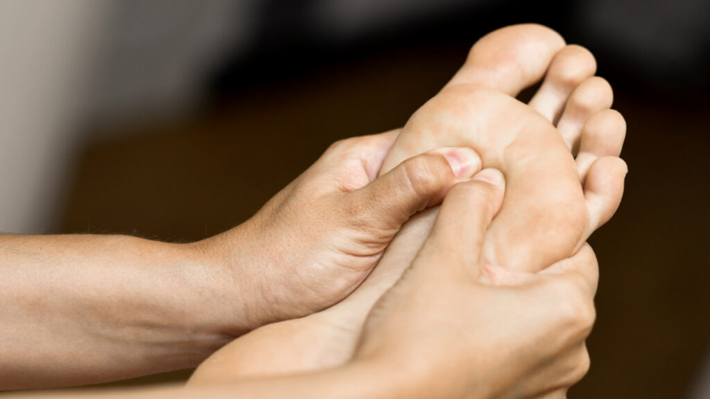 Un fisioterapia realiza un masaje en el pie