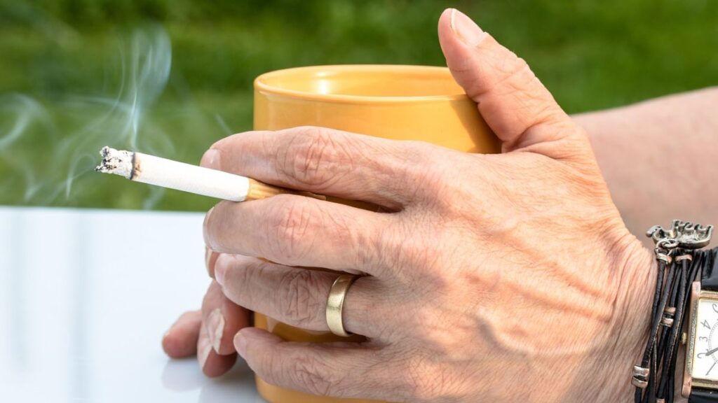 Una persona con un cigarro en la mano. 
