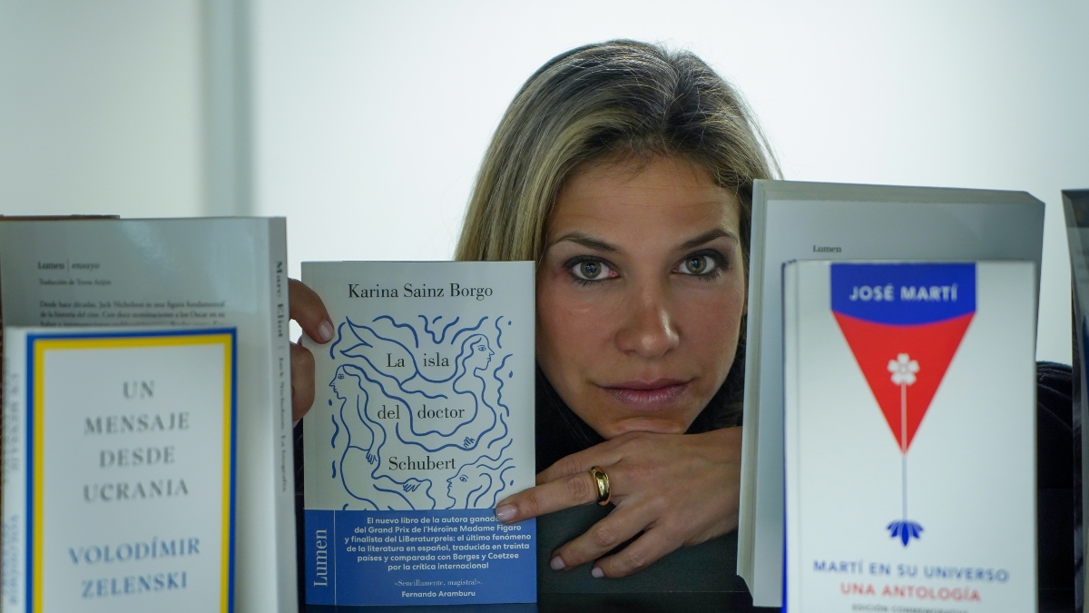 Karina Sainz Borgo posa junto a la antología del poeta cubano José Martí y el libro del presidente de Ucrania, Volodimir Zelenski, con su novela 'La isla del doctor Schubert'. Foto: Víctor Ubiña.