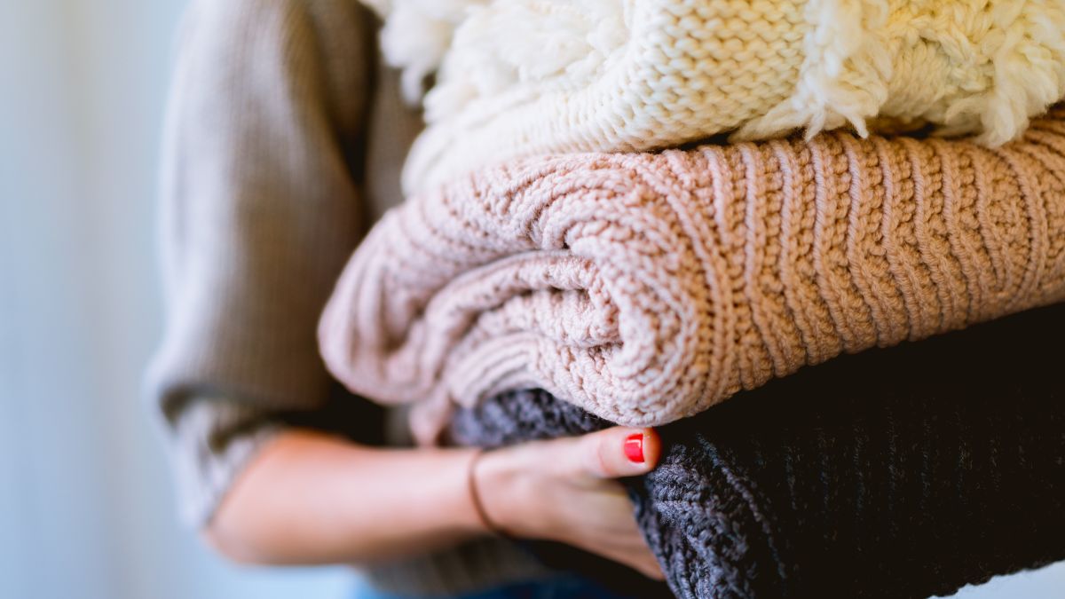 Una mujer con ropa doblada. 