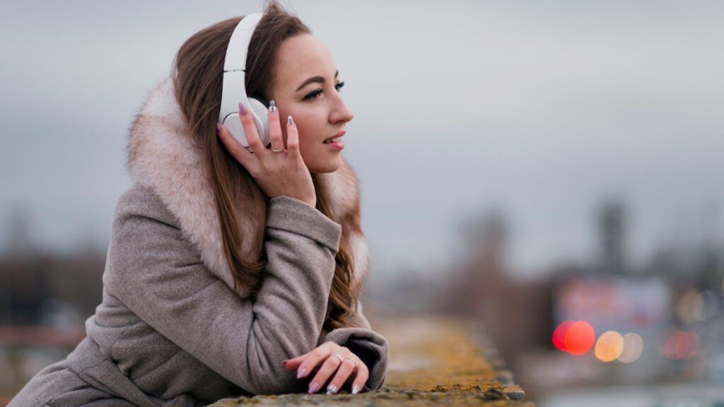 Una mujer con auriculares de cancelación de ruido se protege de la contaminación acústica