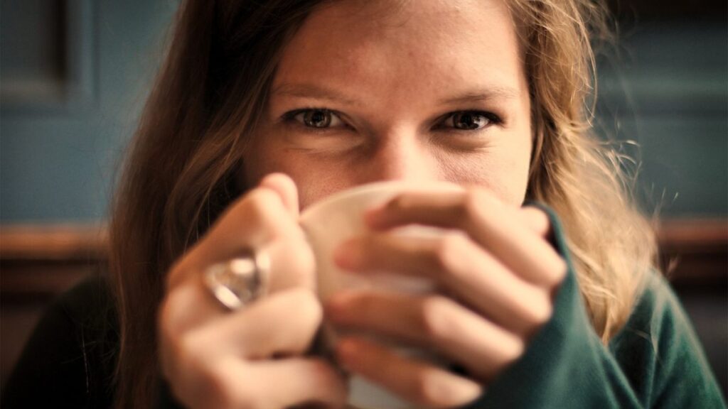Una mujer bebiendo de una taza. 
