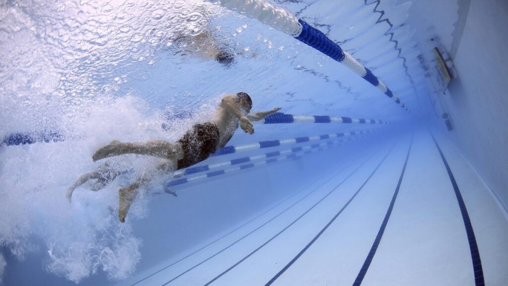 Un hombre nadando en una piscina. 