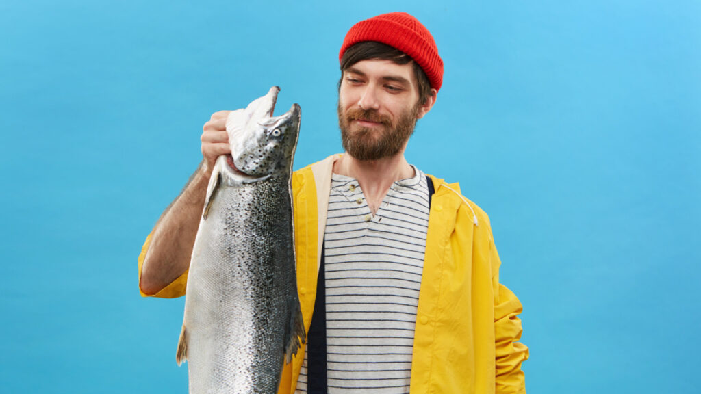 Un hombre sostiene un salmón con la mano