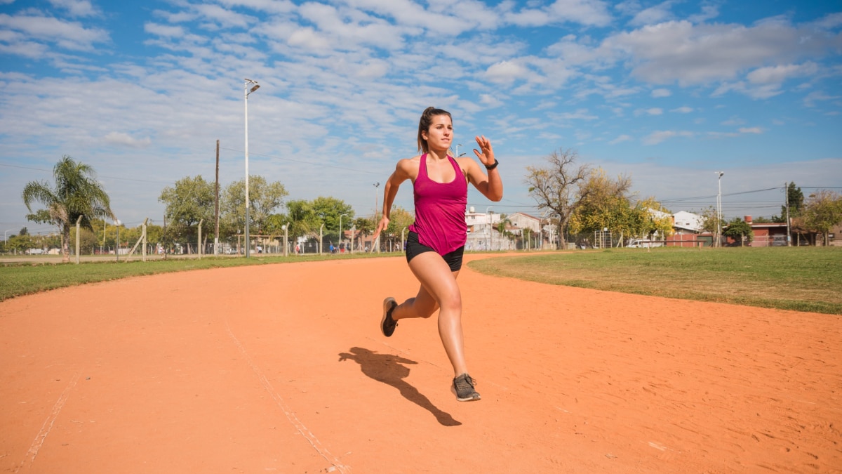 Una mujer joven corre en una pista de tierra