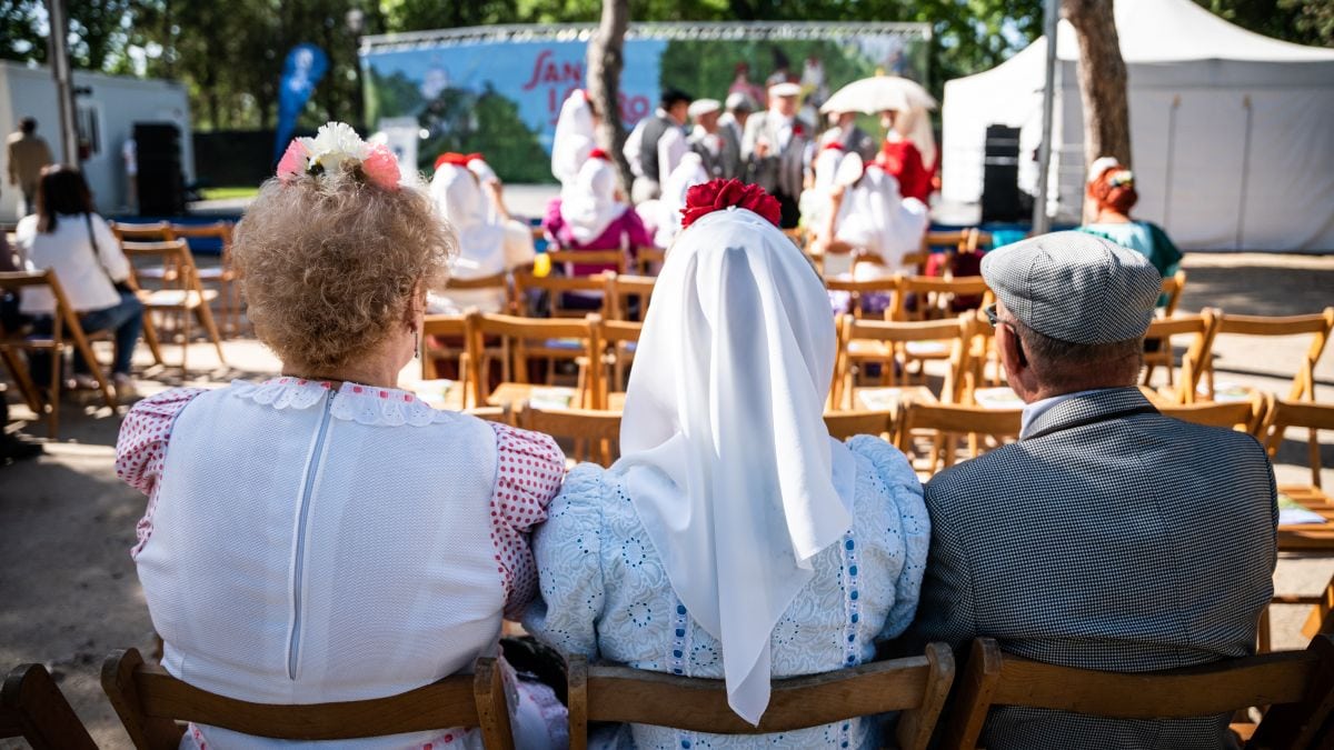 Tres personas vestidas de chulapas de espaldas. 