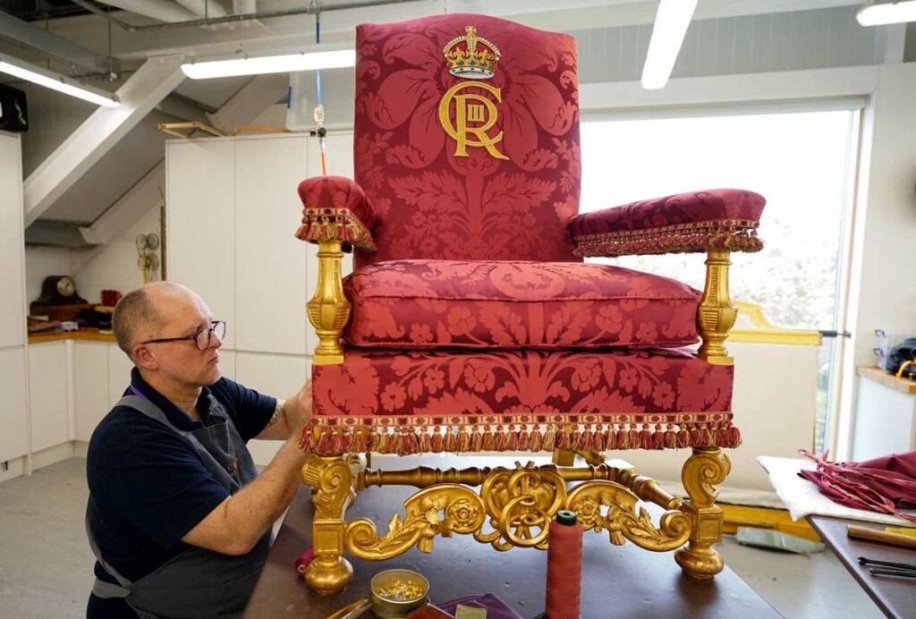 Un miembro de la Casa Real pone a punto el trono del rey Eduardo, la silla de la coronación