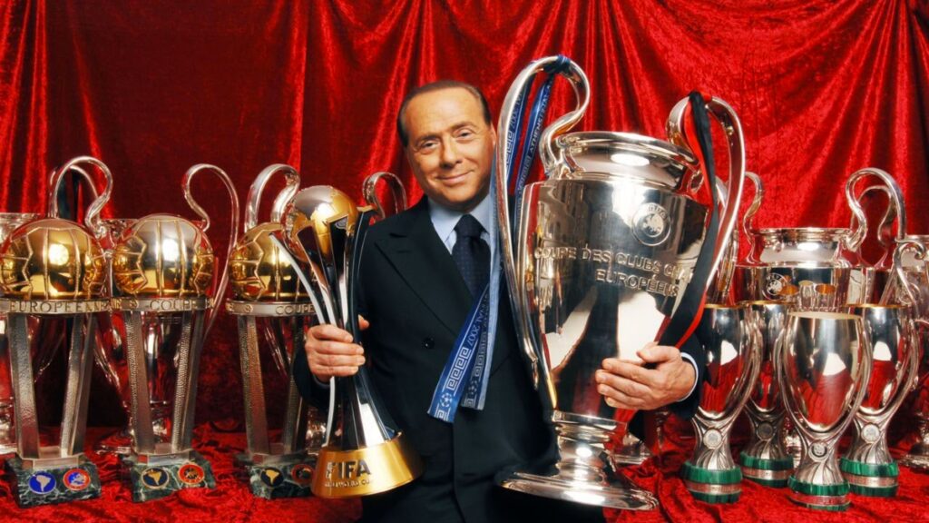 El empresario y político italiano, Silvio Berlusconi, posando junto a los trofeos conseguidos durante su mandato al frente del AC 