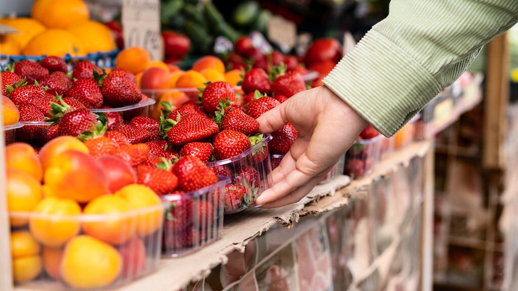 Un hombre elige frutas en un supermercado