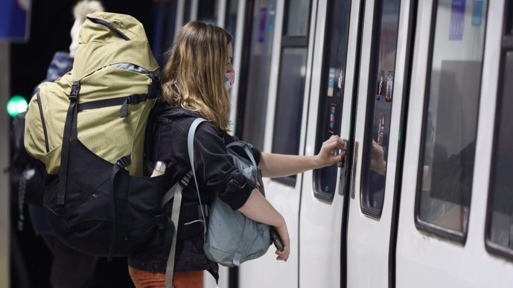 Una mujer abriendo la puerta de un vagón del metro. 