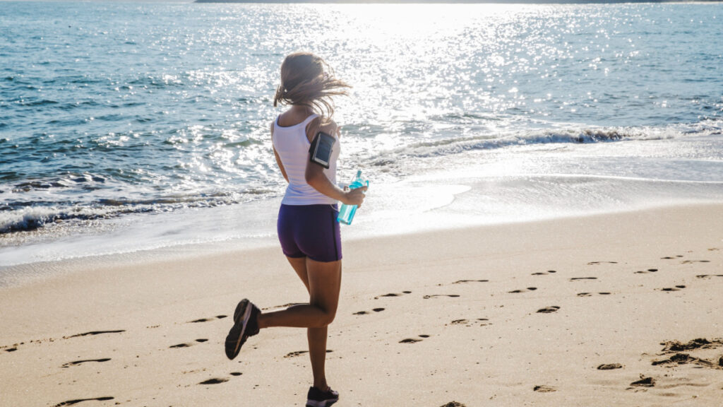 Una mujer corriendo en la playa.