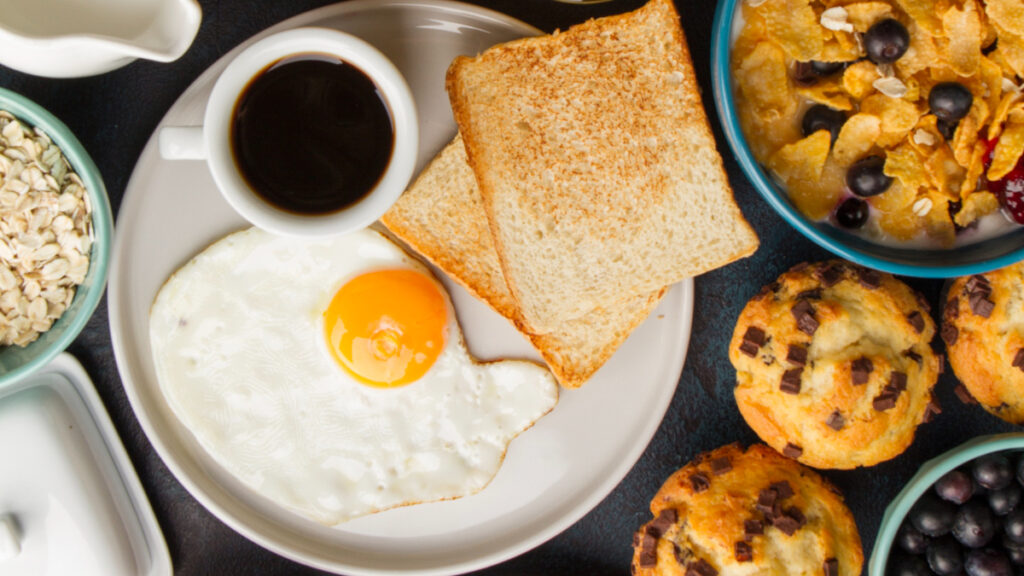 Un desayuno con café, huevos y bollería