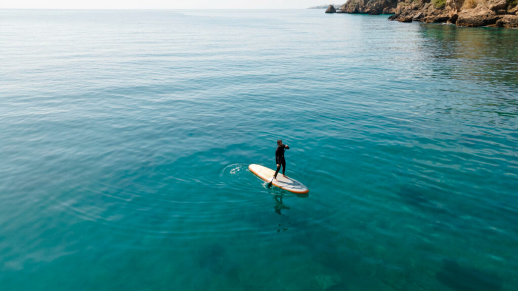Un hombre disfrutar de los beneficios del paddle surf en el mar