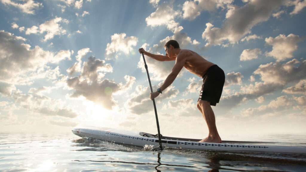 Un hombre joven hace paddle surf