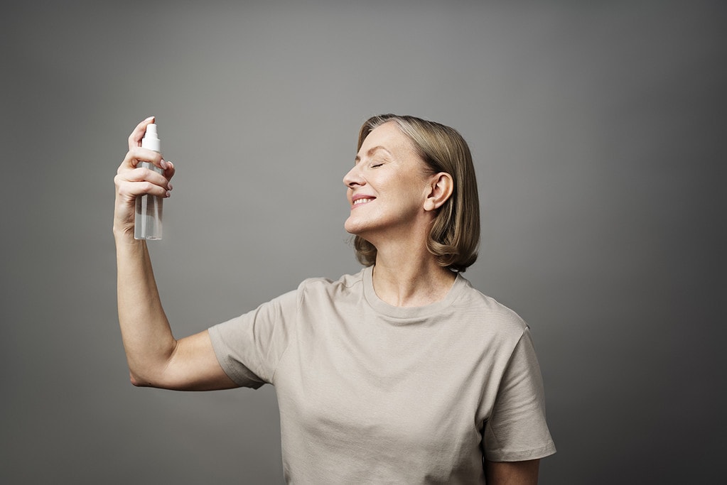 Mujer utilizando fijadores de maquillaje en spray. (Fuente: Freepik)