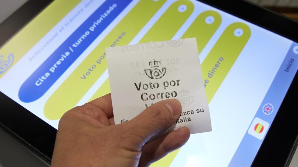 Una persona con un ticket de voto por correo en la oficina de Correos de Cibeles, Madrid.