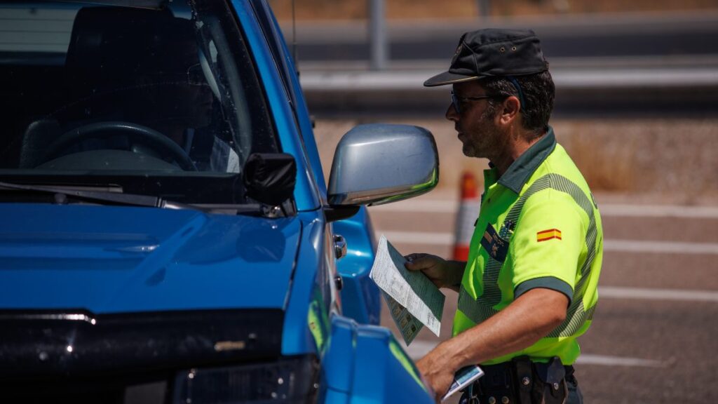Un guardia civil revisando la documentación de un conductor