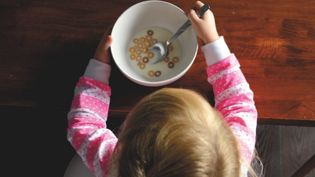 Una niña comiendo cereales con leche