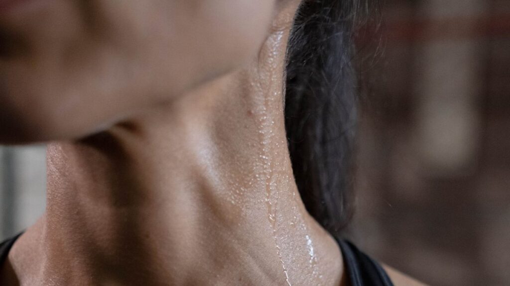 Una mujer sudando en el cuello.