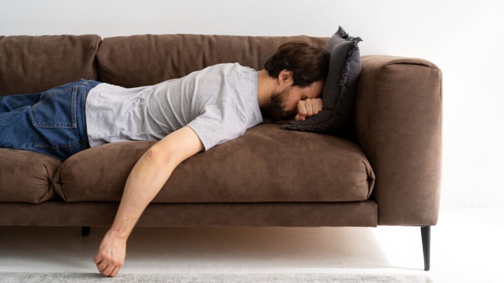 Un hombre con hipersomnia tumbado en el sofá