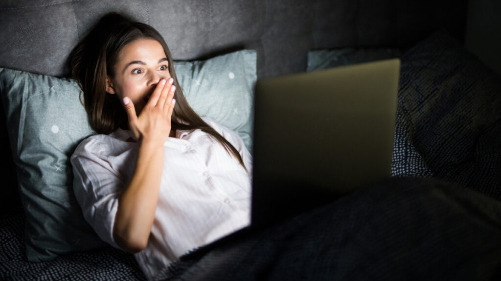 Una mujer con el ordenador en la cama sin entender los peligros de trasnochar