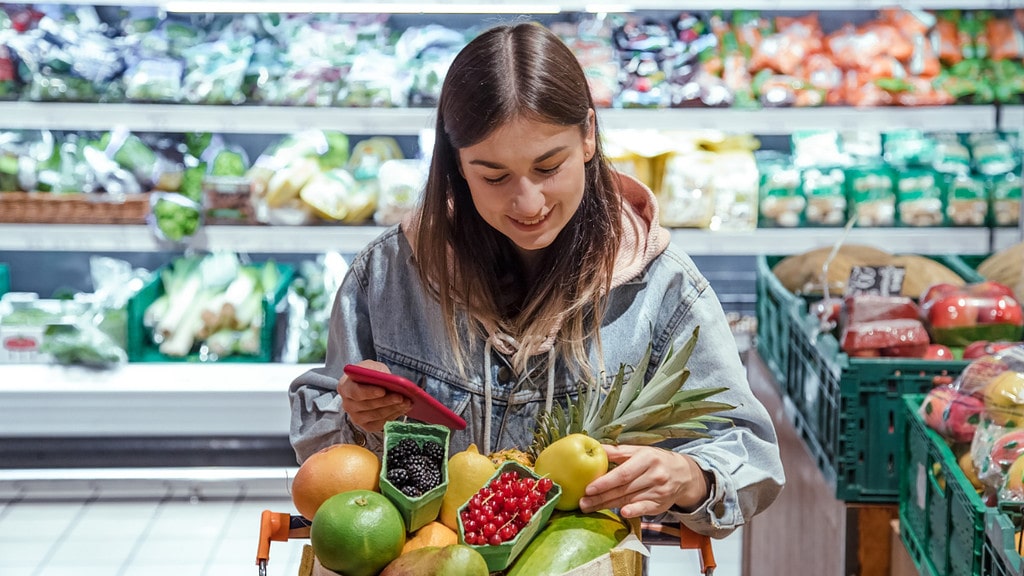 Una mujer cuenta calorías mientras hace la compra