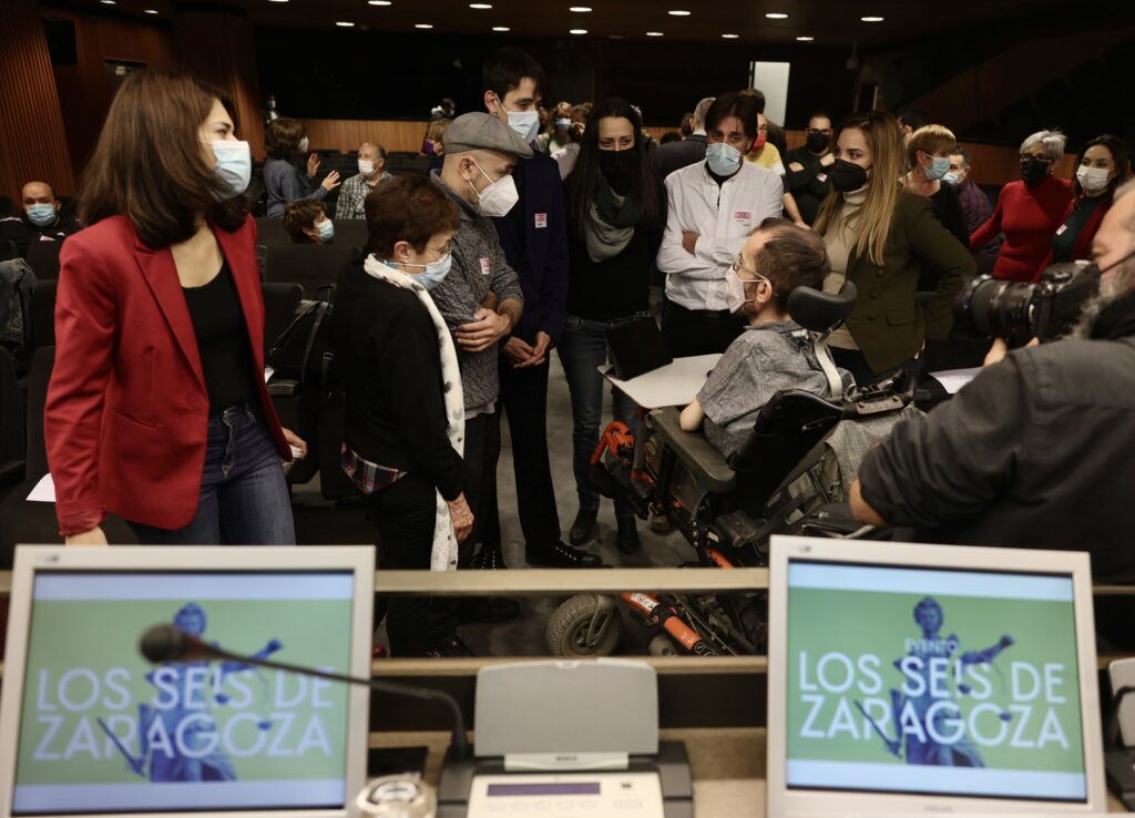 Isa Serra y Pablo Echenique junto a familiares de los 'seis de Zaragoza', en las jornadas informativas en el Congreso de los Diputados, el 15 de diciembre de 2021.