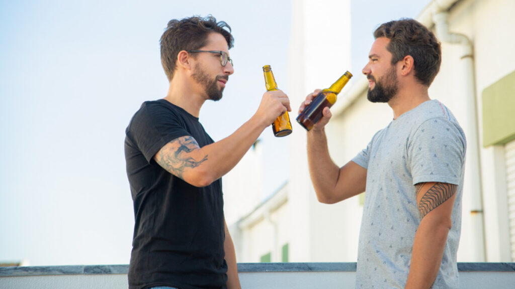 Dos hombres beben alcohol después de hacer deporte