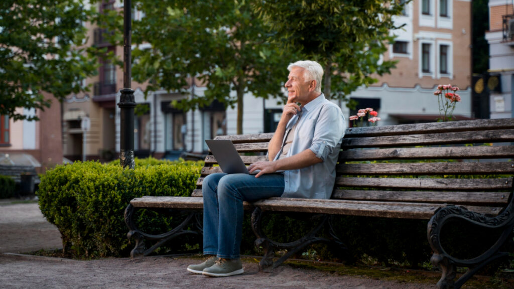 Un hombre con un ordenador sentado en un parque