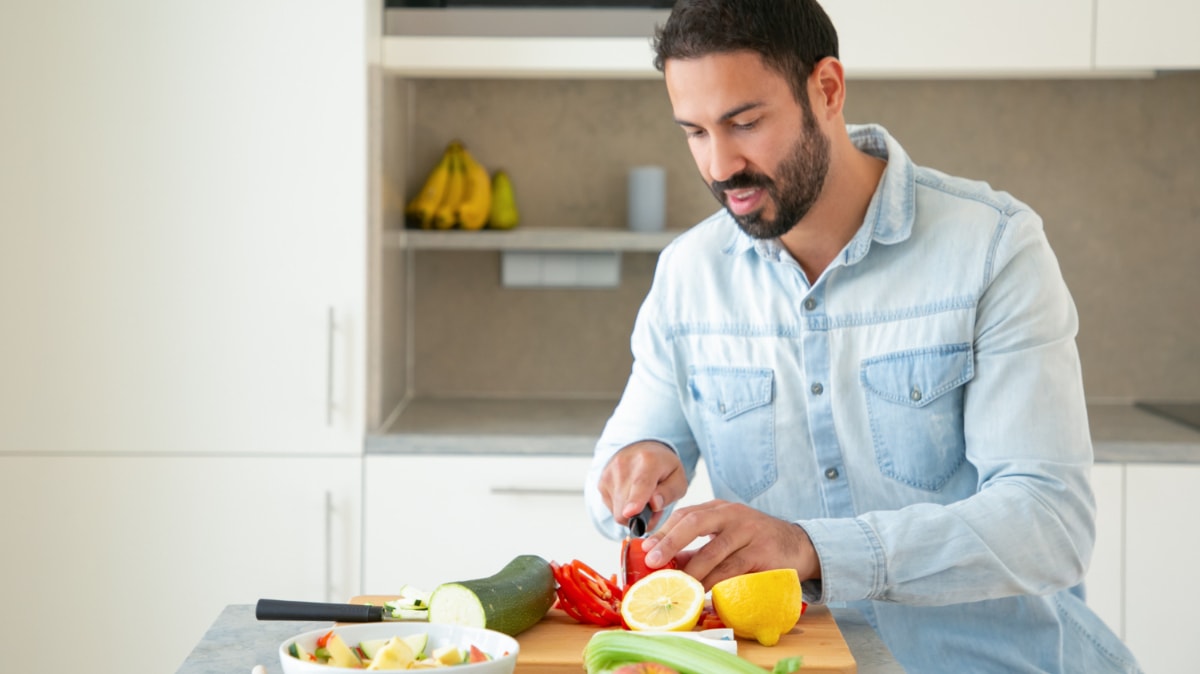 Un hombre prepara verduras, que protegen la próstata