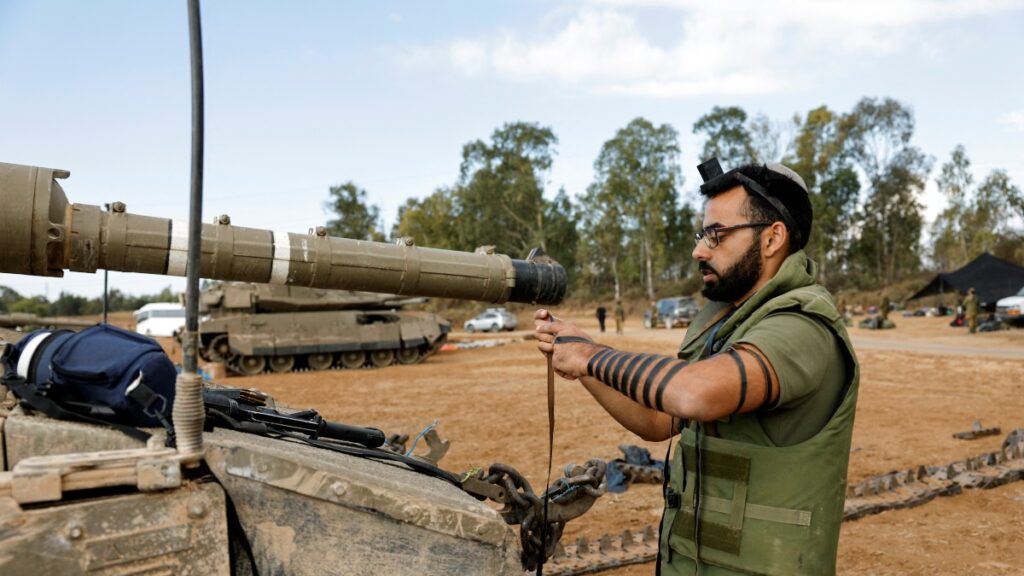 Un soldado israelí realiza los rezos de la mañana junto a un tanque. Foto: Reuters.