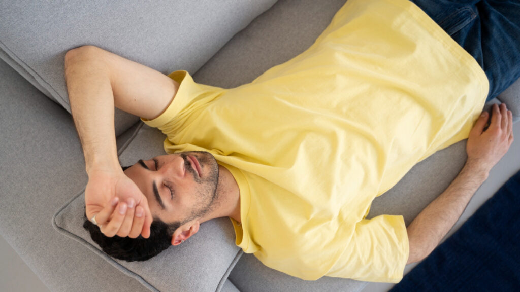 Un hombre duerme sin despertador en un sofá