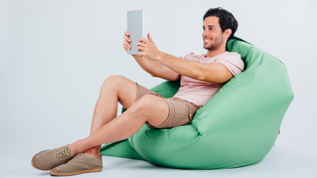 Un hombre está sentado en una butaca con una tablet