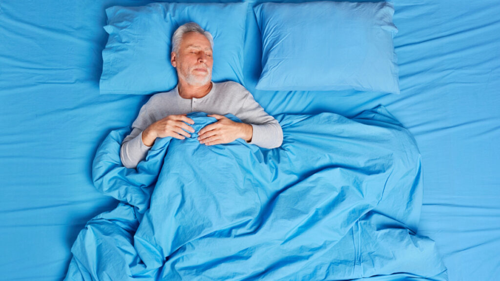 Un hombre se va a dormir en una cama azul